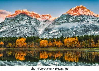 Early Morning Sun Lighting The Peaks Behind Wedge Pond, Kananaskis Alberta