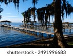 Early morning sun shines across Lake Waccamaw on some docks and boats.