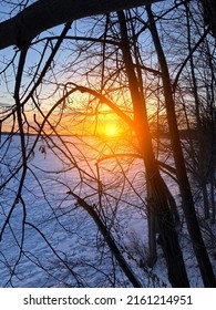 Early Morning Sun Shining Across A Snow Covered Lake