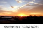 Early morning sunrise in Carmel, Indiana near Indianapolis. Crossing contrails in sky over the crossroad center of America.