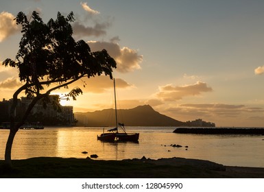 Early morning sunrise at dawn illuminates clouds over Diamond Head and Waikiki Beach area of Oahu in Hawaii