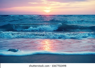 Early Morning Sunrise on Waimanalo Beach on Oahu, Hawaii bursting through the clouds. 2012. Tide at dawn. waves beat the sea foam on the sand on the beach - Shutterstock ID 1067702498