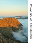 Early morning sunshine on Lingmell above the clouds and mist in Wasdale, Styhead Pass, and corridor route to Scafell Pike. Photographed in June 2024 from Great End