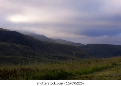 Early Morning View In The Central Drakensberg, South Africa, With A Low Lying Cloud Cover Obscuring The Highest Peaks In The Distance, As Seen From The Loteni Campsite