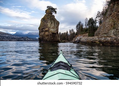 Early Morning View From A Kayak Of Siwash Rock In Stanley Park, With North Vancouver, BC, Canada, In The Background.