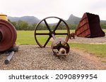 Early morning view of old machinery at an abandoned historical mining town of Mount Britton in Central Queensland, Australia, against a background of hills and escarpments,