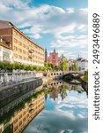 Early morning view towards Franciscan Church and Triple Bridge with reflection in Ljubljanica river in Ljubljana, Slovenia