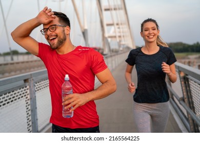 Early Morning Workout. Happy Couple Running Across The Bridge. Living Healthy Lifestyle.