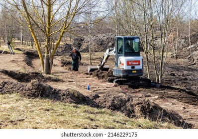 Early Spring Small Bobcat Excavator With Rubber Tracks In The Park Digging The Ground. Panevezys, Lithuania, April, 15 D.