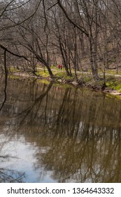 Early Spring Walkers In Red Shirts Along The Perkiomen Creek Foot Path In Lenape Park Perkasie, Bucks County Pennsylvania