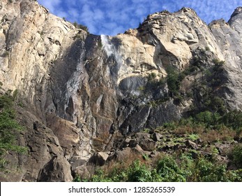 Early Spring In Yosemite Means Melted Snow, Which Thus Means The Humble Beginning Of A Mighty Waterfall. The Water Dusts The Rock And Trees Below, Playfully Saying Hello.