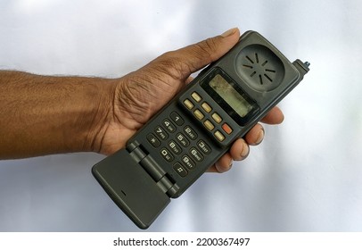 Early Stages Old Vintage Mobile Phone, Antenna Cellular Phone, Cell Phone, Cellphone, Handphone Or Pocket Portable Telephone Isolated In Hand On White Background