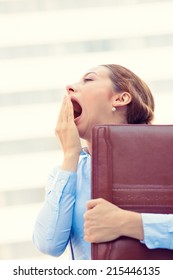 Its Is Too Early For This Meeting. Closeup Portrait Sleepy Young Business Woman, Running To Work Wide Open Mouth Yawning, Eyes Closed Looking Bored Isolated Outside Corporate Office Windows Background