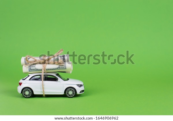 Earn cash\
with your car concept. Side profile full photo picture of small\
white car with rolls piles of usd money on top isolated bright\
color background with copyspace\
card