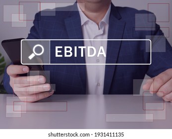 Earnings Before Interest, Taxes, Depreciation and Amortization EBITDA phrase on the screen. Loan officer use cell technologies at office. 
