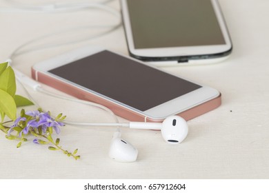earphone and two mobile on background white table