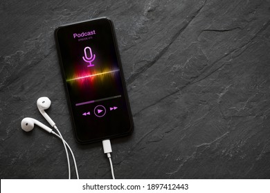 Earphones and mobile phone with podcast app on screen - Shutterstock ID 1897412443