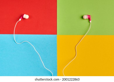 Earphones on colorful background of famous computer corporation, software manufacturer logo. Audio software concept. Red, green, blue, yellow paper colours. Corporation logo.
