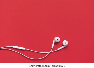 Earphons on red background. - Shutterstock ID 688246021