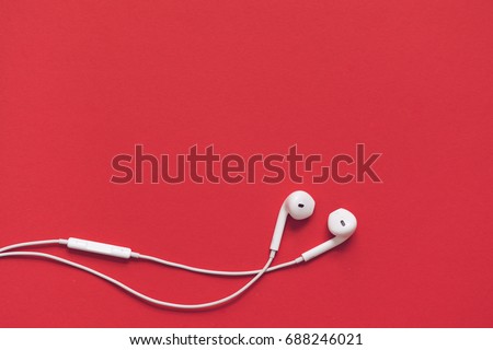 Earphons on red background.