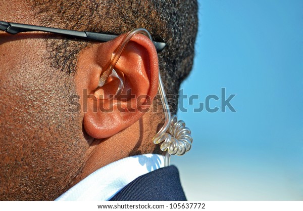 earpiece in a Secret\
Service agent\'s ear