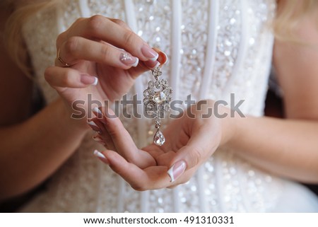 Earrind in the hands of the bride