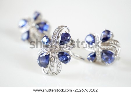 earring and ring set with big blue tanzanite and white diamonds around, jewerly shop, pawnshop concept, closeup