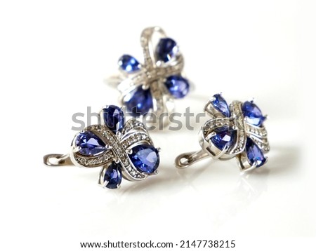 earring and ring set with big blue tanzanite and white diamonds around, jewerly shop, pawnshop concept, closeup