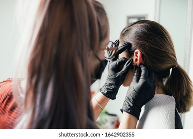 Ears piercing the girlin black background