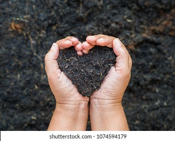 Eart Day, Save The Earth, Love Concept. The Woman Hand Holding A Soil On Ground Blur Background.