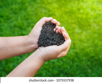 Eart Day, Save The Earth, Love Concept. The Woman Hand Holding A Soil On Green Grass Blur Background.