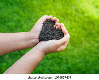 Eart Day, Save The Earth, Love Concept. The Woman Hand Holding A Soil On Green Grass Blur Background.