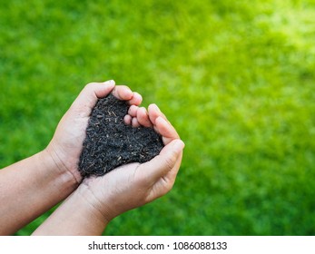 Eart Day, Save The Earth, Love Concept. The Woman Hand Holding A Soil On Green Grass Blur Background.