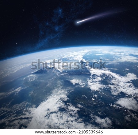 Earth and comet from space. Comet flying near the Earth. Comet flying through space close to the Earth. The concept of the apocalypse, armageddon, doomsday. Elements of this image furnished by NASA.