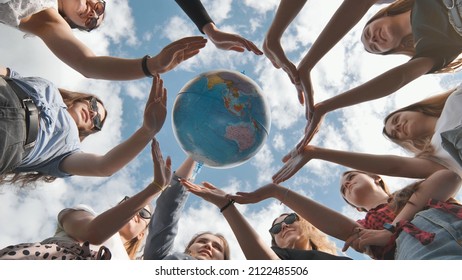 Earth conservation concept. 11 girls surround the rotating earth globe with their palms hands. - Powered by Shutterstock