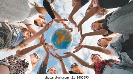 Earth conservation concept. 11 girls surround the rotating earth globe with their palms hands. - Powered by Shutterstock