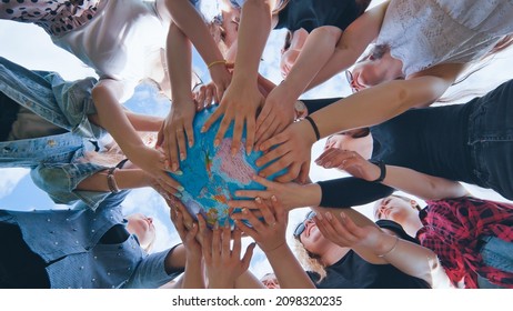 Earth conservation concept. Girls hug the earth globe with their hands. - Powered by Shutterstock