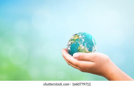 Earth Day Concept: Hand Holding Global Over Blurred  Nature Background