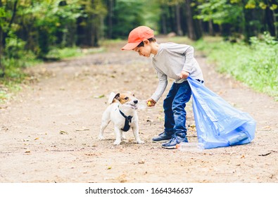 Earth Day Concept With Kid And Dog Cleaning Park Gathering Plastic Bottles