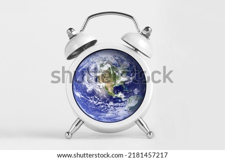 Earth day concept. Planet Earth globe with alarm clock.