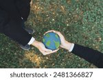 Earth day concept, top view businessman giving Earth globe as CSR corporate social responsible principle to promote environmental awareness and embrace ESG for greener and sustainable future. Gyre