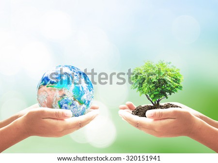 Earth Day concept: Two human hands holding earth globe and heart shape of tree over blurred green nature background. Elements of this image furnished by NASA