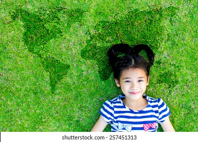 Earth Day, International Children's Day, And Universal Children Day Concept With Happy Asian Kid Relaxing Peacefully On World Map Green Lawn