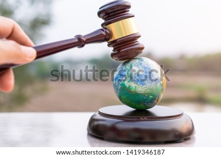 Earth destruction and destroy environmental by hand human concept. Judge gavel / world model should have legal force or certification for survival of all mankind with international Environment law
