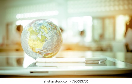Earth globe model ball map with class room background on tablet in classroom. Concept for global international educaiton or communications, politics environmental for learning world wide. vintage tone