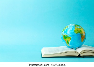 Earth globe on an open book on a blue banner background. Knowledge, learning, study concept. Backagrund education