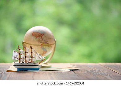 Earth globe, wooden ship model on natural background. Happy Columbus Day, National holiday USA concept. travel, exploration, sea cruise, adventure symbol. copy space