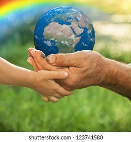Earth in hands of old man and child against green spring background. Ecology concept - Shutterstock ID 123741580