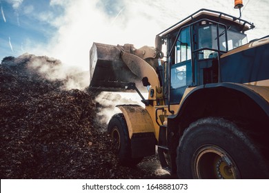 Earth Mover Working On Pile Of Compost In Industrial Facility