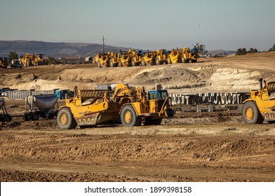 Earth Moving Equipment At A Construction Grading Site With Other Tractors Lined Up In The Background